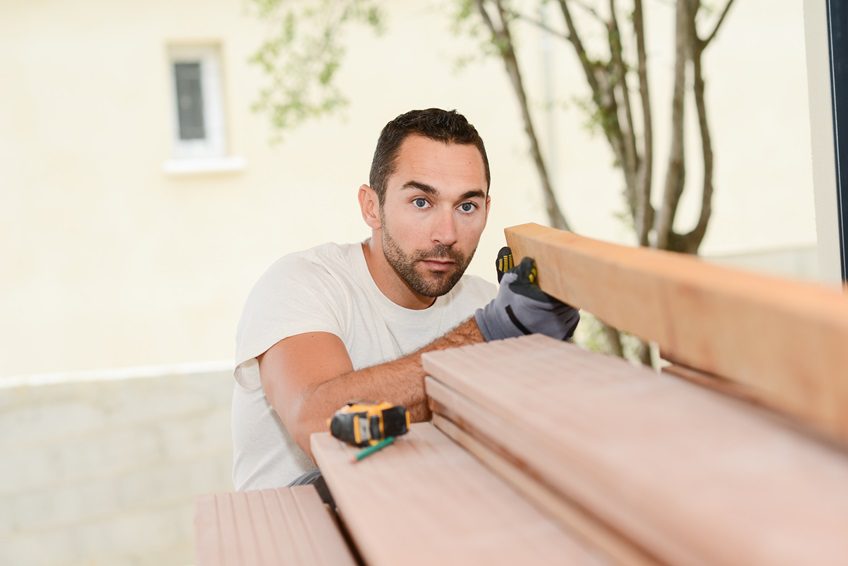 Man measuring composite decking joists before cutting