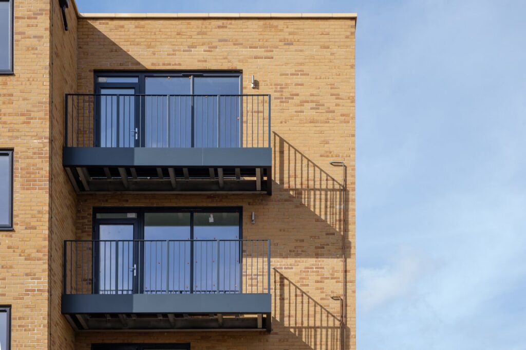 Two balconies at the top of a building fitted with aluminium decking